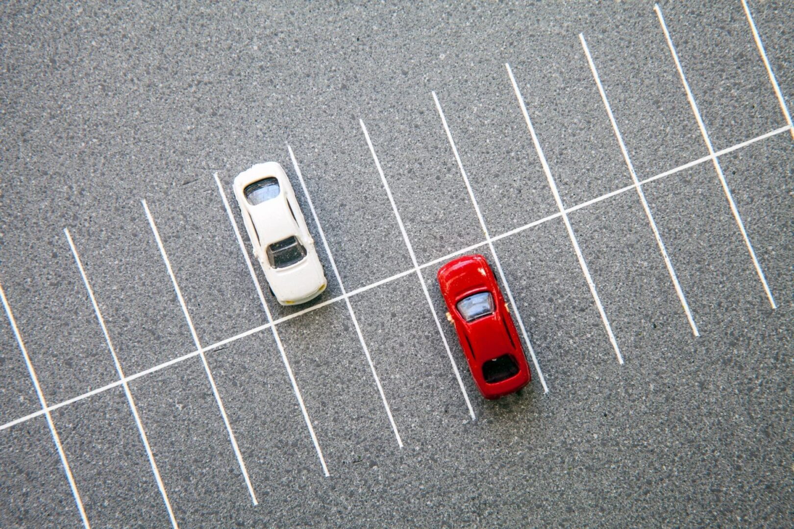 Two toy cars in a parking spot